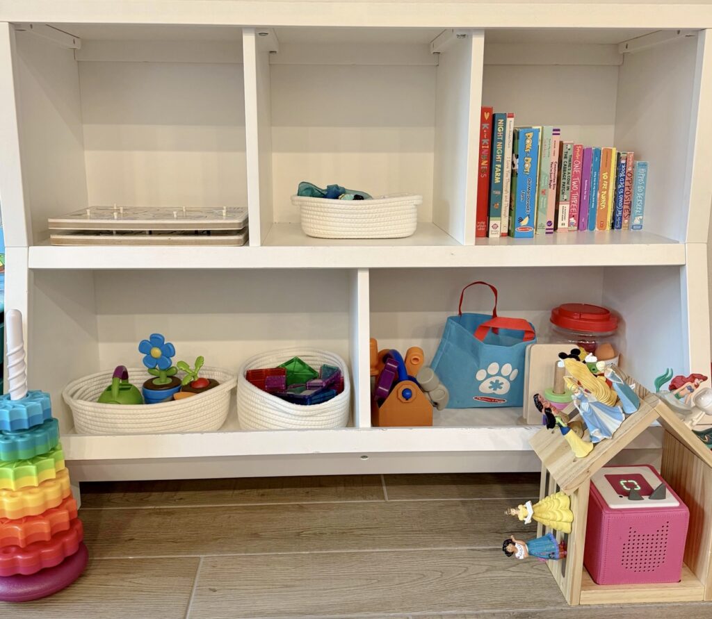 Toddler toy setup with toys in baskets on shelves to make toy rotation easier.